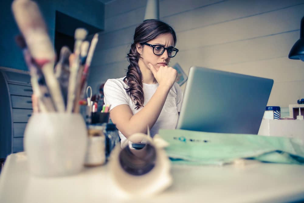 Confused woman looking at laptop