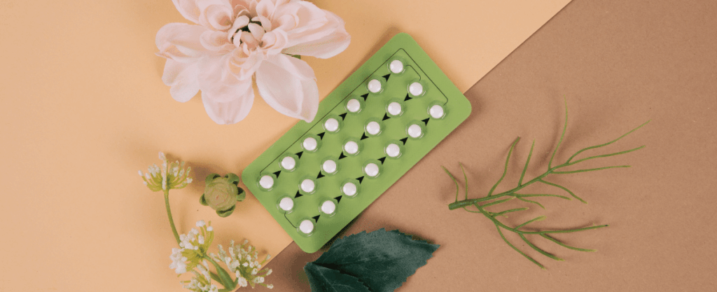 contraception next to flowers and leaves on brown background