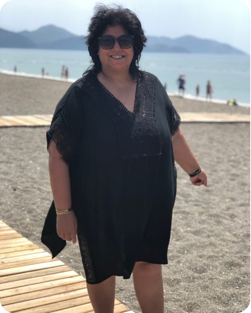 Photo of woman on the beach in short black dress and sunglasses