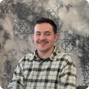 Image of Dylan in a checked shirt, smiling